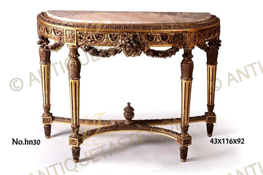 An impressive and extremely high quality French 19h century Louis XVI style carved and giltwood freestanding console table with exceptional carvings throughout, Raised by four circular fluted tapered legs headed with carved acanthus leaves and terminate with lotus carvings above blocks with rosettes and ending by topie shaped supports with lotus carvings as well, The legs are joined by a curved X stretcher carved with Egg-and-Dart pattern and centered with Urn of Prosperity, The D shaped top inset with beveled marble top bordered with leaf-and-dart on a Cyma Recta style reversa border above the opulent apron intricately carved with ovolo egg-and-dart centered each with acanthus spinosus leaf amidst blocks embellished by dimensional flower rosettes, centered with knotted bands above a foliate cabochon with fluttering ribbon issuing swaged blossoming floral garlands terminating at each end with tied ribbons